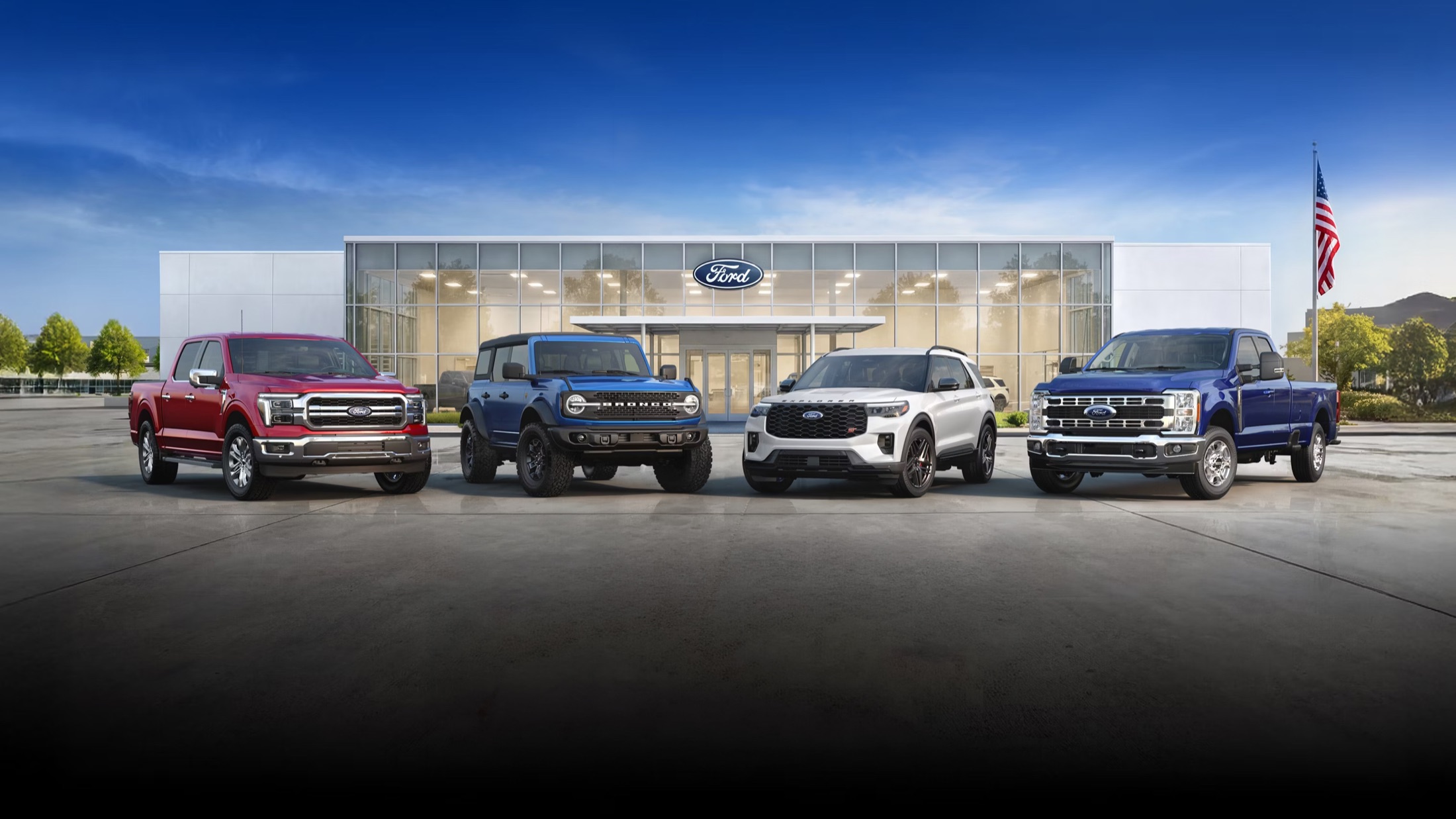 A lineup of trucks and SUVs in front of a dealership